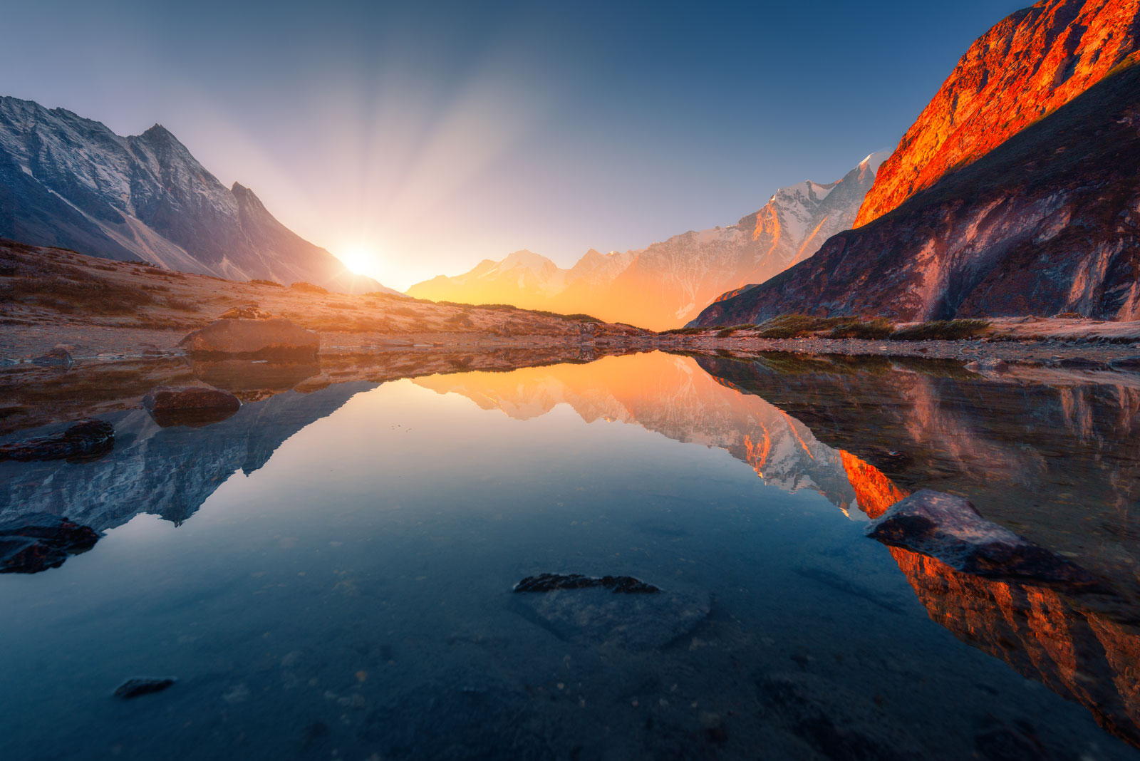 A canyon river surrounded by mountains during sunrise